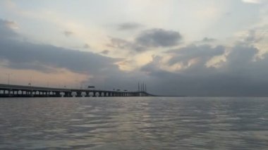 Güneş ışınları denizdeki siluet köprüsünden geçiyor. Sabahları dramatik bulut oluşumu