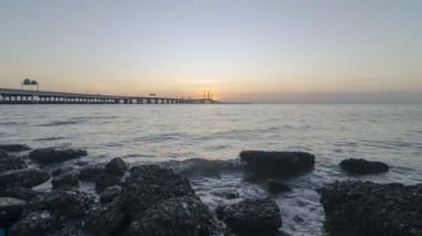 Batu Maung sahilinde gün doğumu zamanı. Arka plan mimari, Penang Köprüsü deniz timsahı.