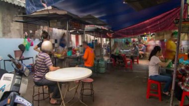 Çinliler, Hawker Center 'ın dışında yemek yer.