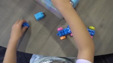 Yüksek açı bir kız aşağı bakın tuğlayı sökün ve konteynırı geri tutun.