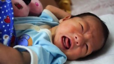 Yeni doğan bebek yatakta ağlar. Ebeveynlik, aşk, aile kavramı