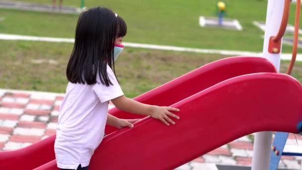 Little Girl Face Mask Playground Slide Different Direction — Stock Video