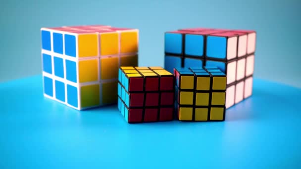 Conceptuele Grote Kleine Rubik Kubus Roteren Blauwe Achtergrond — Stockvideo