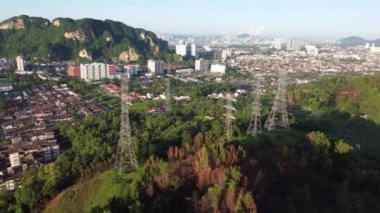 Arka planı Batu Mağaraları olan hava manzaralı elektrik kulesi