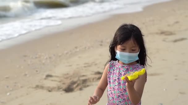 Китаянка Маске Лица Показывает Инструмент Краба Песка Пляже — стоковое видео