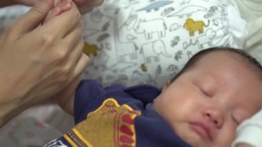 Yeni doğan bebek tırnağını kapat. Anne tırnağını kesiyor.