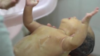 Yeni doğmuş bir bebek, annesinin banyosu sırasında ağlar. Annelik, aile kavramı