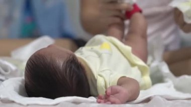 Yatakta odak oğlan seç. Anne kakayı temizle ve bezini sar.