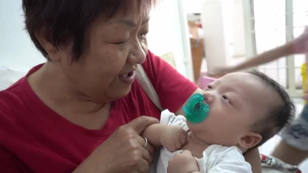 Chinese Grandmother Cuddle Baby Boy Chewing Pacifier — Stock Video