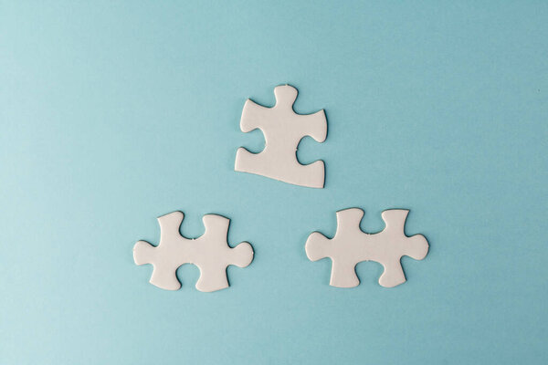 Pieces of white jigsaw puzzle on blue background