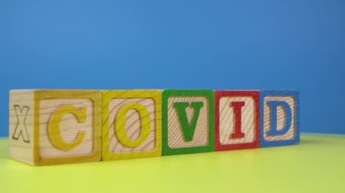 Yüzeyde dönen tahta alfabe COVID bloğu