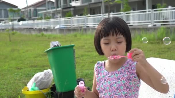 Küçük Kız Oyun Alanındaki Çöp Kutusunun Yanında Baloncuk Üflüyor — Stok video