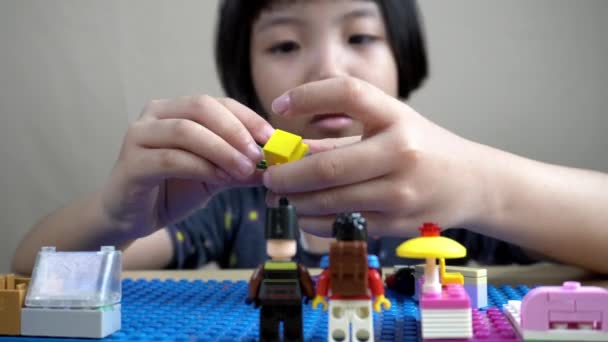 Klein Meisje Hand Spelen Lego Speelgoed Aan Tafel — Stockvideo