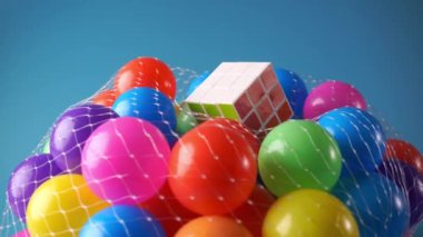 Renkli plastik top üzerinde Rubik küpü mavi arkaplanda döner