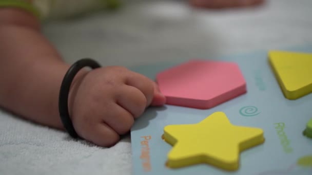 紧紧抓住婴儿的手 躺在玩具形状块的分类旁边 学前教育的概念 — 图库视频影像