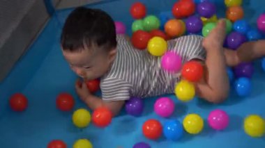 Bebek çocuk oyun parkında topla dolduruluyor. Bebeklik, ev kavramı