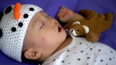Bebek kardan adam şapkası takar Ayı oyuncağıyla uyur