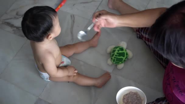 Grandmother Feed Porridge Baby Boy Play Toy Floor — Stock Video