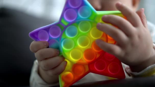 Nahaufnahme Der Hand Des Kleinen Jungen Kauen Regenbogen Sensorischen Spielzeug — Stockvideo