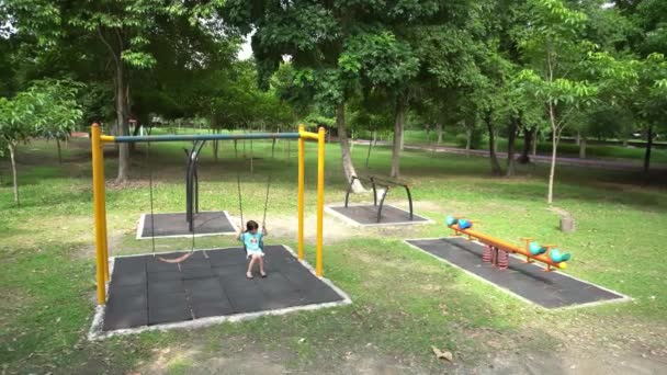 Uma Menina Solitária Jogar Swing Playground Dia Ensolarado — Vídeo de Stock