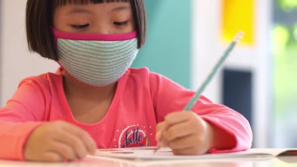 Seleccionar Enfoque Pequeño Niño Chino Usar Mascarilla Escribir Libro — Vídeos de Stock