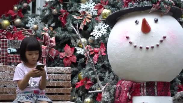 Srác Mobilt Játszik Hóember Dekoráció Mellett Nyaralás Karácsonyi Téma — Stock videók