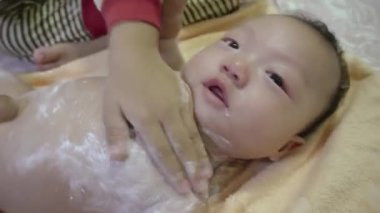 Kız kardeşi, tatlı erkek kardeşine talk pudrası uygular.