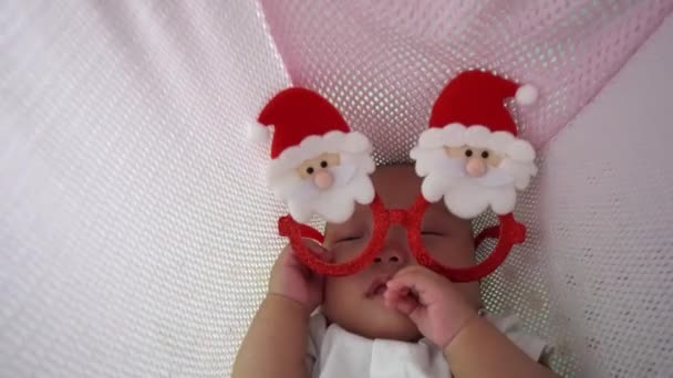 Chinesischer Junge Schläft Schaukel Mit Weihnachtsmann Weihnachtsbrille — Stockvideo