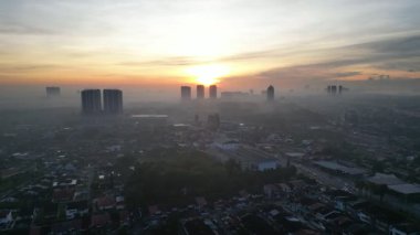 Larkin Skyline 'ın ortasında büyük bir bina var. Güneş batıyor ve gökyüzü bulutlu.