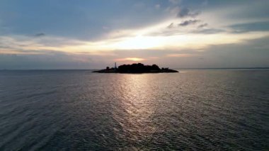 Okyanusun ortasında küçük bir ada var. Su sakin ve gökyüzü bulutlu. Segenting 'in hava manzarası, Batu Pahat.