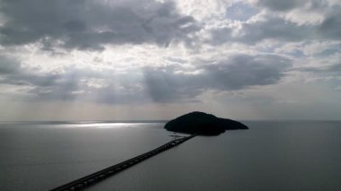 Bir su kütlesi üzerinde bir köprü görülür. Köprü, Kedah, Pulau Bunting 'de küçük bir adada yer almaktadır.