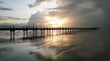 Rıhtımda, suda güneşin yansıması gösterilir. İskele bir plajda. Gökyüzü görüntüsü Yan, Kedah