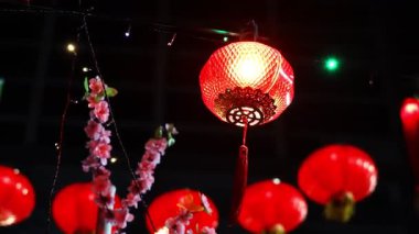 Kırmızı bir fener bir ipten sarkıyor. İpten sarkan birkaç kırmızı fener daha var.