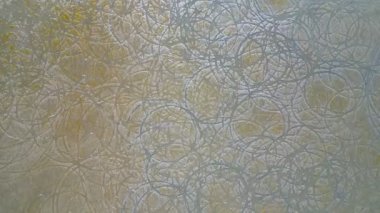 Daireler çizen bir duvar. Daireler beyaz ve duvar bronzlaşmış. Daireler birbirine çok yakın.