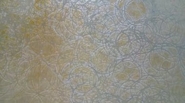 Daireler çizen bir duvar. Daireler beyaz ve duvar bronzlaşmış. Daireler birbirine çok yakın.