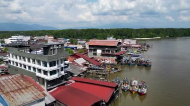 Arka planda nehir olan bir kasaba. Nehir teknelerle dolu. Hava Kuala Sepetang Kasabası
