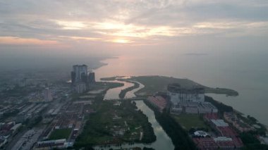 İçinden nehir akan bir melaka kasabası. Nehir büyük bir su kütlesinin yanındadır.