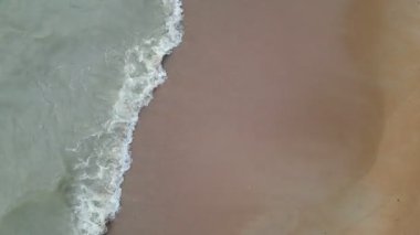 Pembe renkli suyu olan bir sahil. Kumsal kumlu.