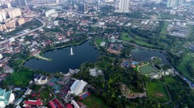 Büyük bir gölü ve ortasında bir çeşmesi olan bir şehir. Şehir binalar ve parklarla dolu. Hava Tasik Titiwangsa