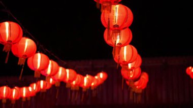 Tavandan sarkan kırmızı fenerler. Fenerler yanıyor. Görüntüde bir sürü fener var.