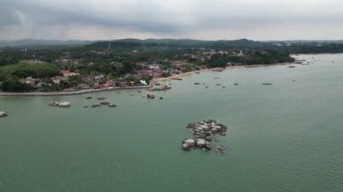 Kayalık bir kıyı şeridi olan deniz. Kıyı şeridi evler ve binalarla dolu. Hava görüntüsü Tanjong Bidara, Melaka