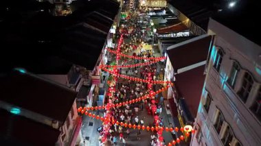 George Town, Penang, Malezya - 18 Ocak 2025: Lebuh Presgrave caddesi, binalardan sarkan birçok insan ve kırmızı fenerlerle dolu. Fenerler yanıyor, neşeli bir atmosfer yaratıyorlar.