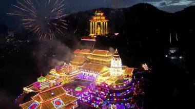 Ayer Itam, Penang, Malezya - 25 Ocak 2025: Kek Lok Si tapınağının havadan görünüşü göz kamaştırıcı havai fişeklerle aydınlanıyor, gece gökyüzünü ışıl ışıl aydınlatıyor.