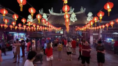 George Town, Penang, Malezya - 28 Ocak 2025: Kalabalık, Çin Yeni Yıl kutlamalarında parlayan kırmızı fenerlerle çevrili Merhamet Tanrıçası tapınağında toplandı.