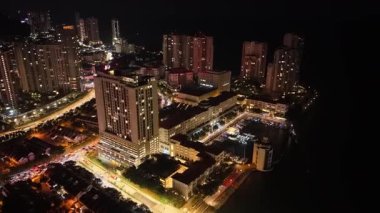 Tanjung Tokong 'un rıhtım, marina, aydınlık binalar ve kıyı trafiğini gösteren gece hava aracı görüntüleri..