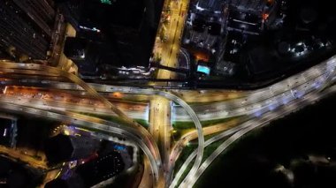 Hava görüntüleri, gece araba trafiğini, şehir ışıklarının altındaki kavşaklardan geçen araçları vurguluyor..