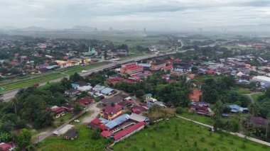İnsansız hava aracı görüntüleri Kubang Semang kasabasını, yerleşim yerlerini, otoyolu, camiyi ve çevresindeki pirinç tarlalarını gösteriyor..