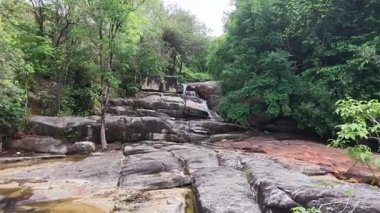 Hava görüntüsü Batu Ferringhi Şelalesi 'ni tropikal orman tepe örtüsü altında kayalık araziyle birlikte çeker..