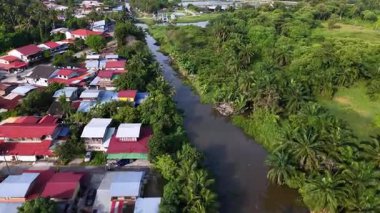 Bukit Tambun 'daki nehir kenarındaki bir balıkçı köyünün havadan çekilmiş görüntüleri. Evleri ve mangrov bitkileri var..