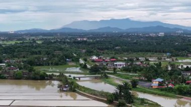 Drone, Sungai Perai 'nin nehir, taşkın pirinç tarlaları, köyler, köprü ve uzak dağları gösteren insansız hava aracı görüntüsü çekti..